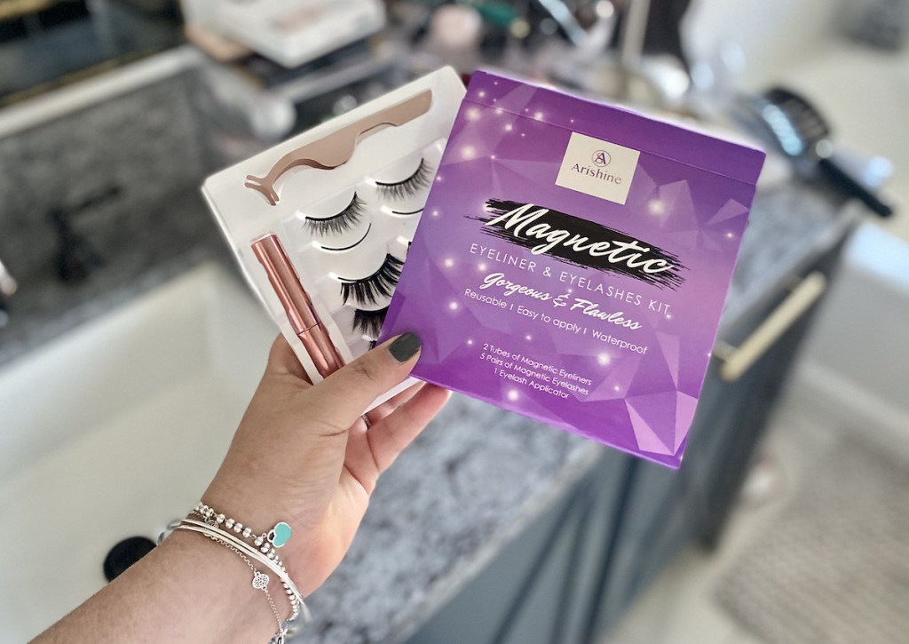 hand holding a box of magnetic lashes in bathroom