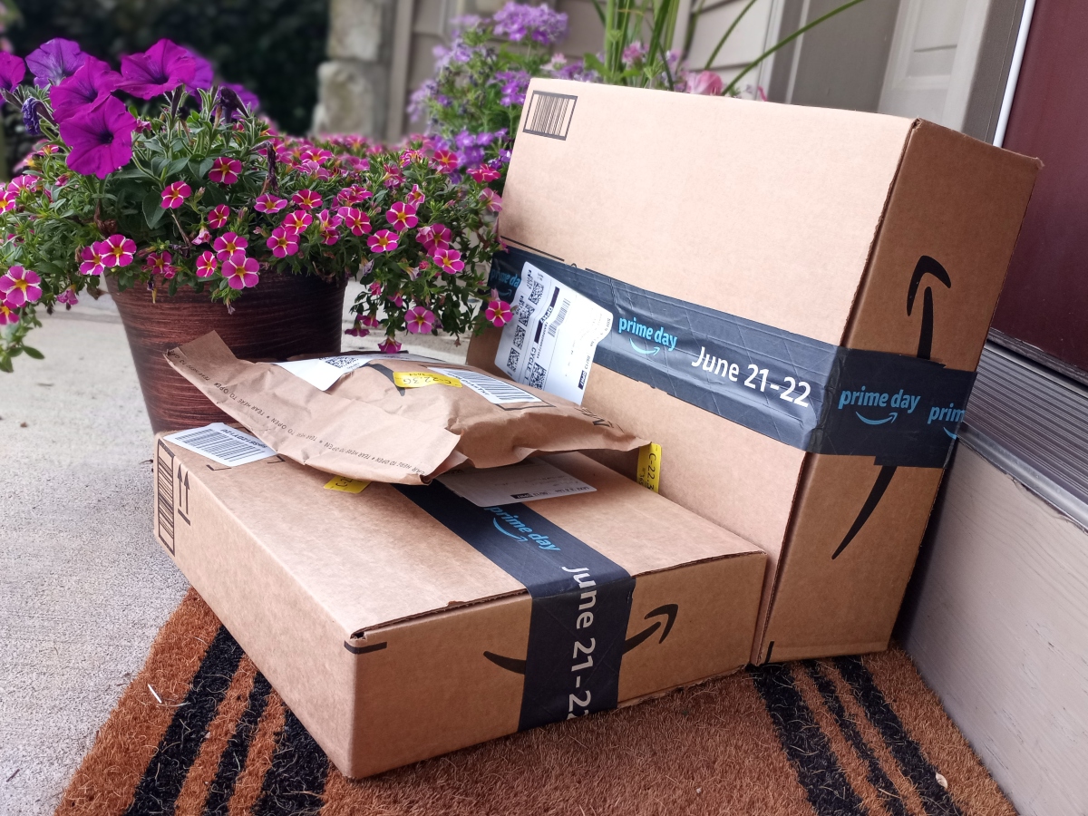 Amazon Household Prime benefits include free delivery like this person with Amazon packages on porch