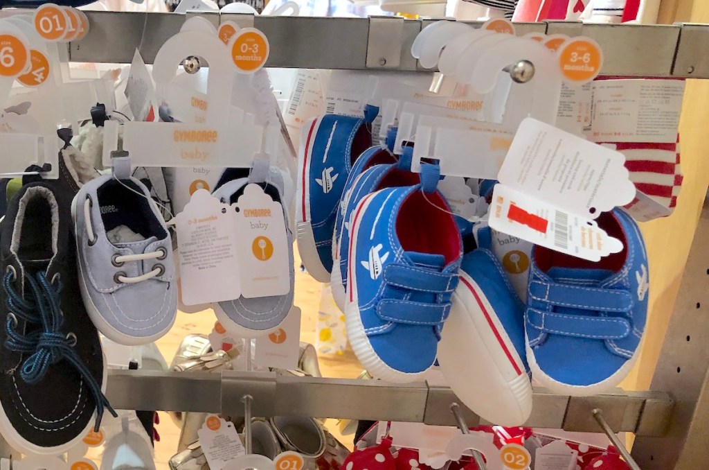 baby shoes hanging on store shelf with gymboree tags on them