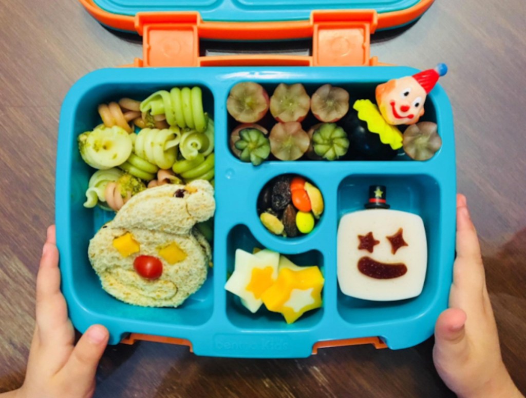 kids hands holding sides of blue organized lunchbox