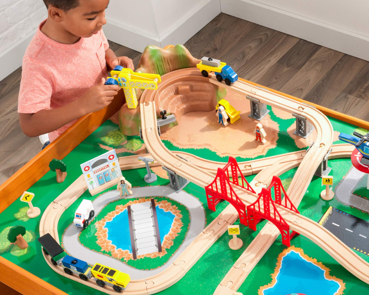boy playing with kidkraft train table