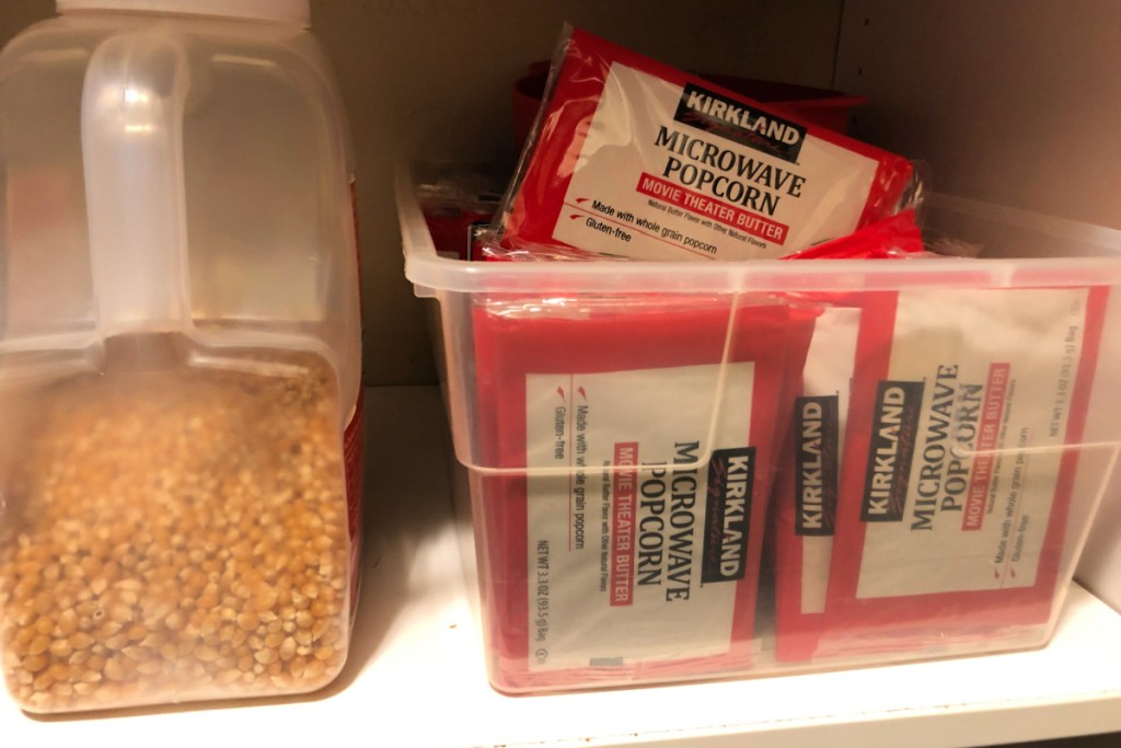 bags of microwave popcorn next to kernels on a shelf