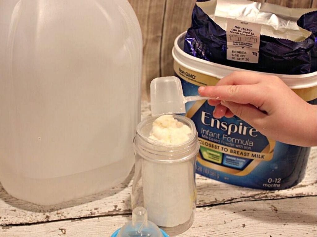hand putting scoops of Enspire powder in bottle