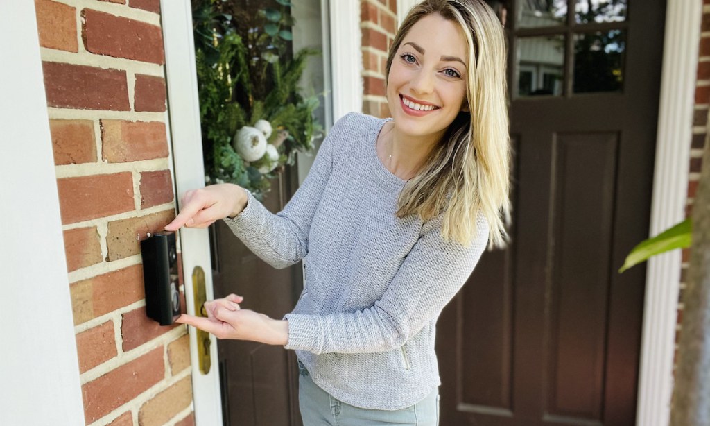 woman standing at door with fingers pointing on eufy doorbell