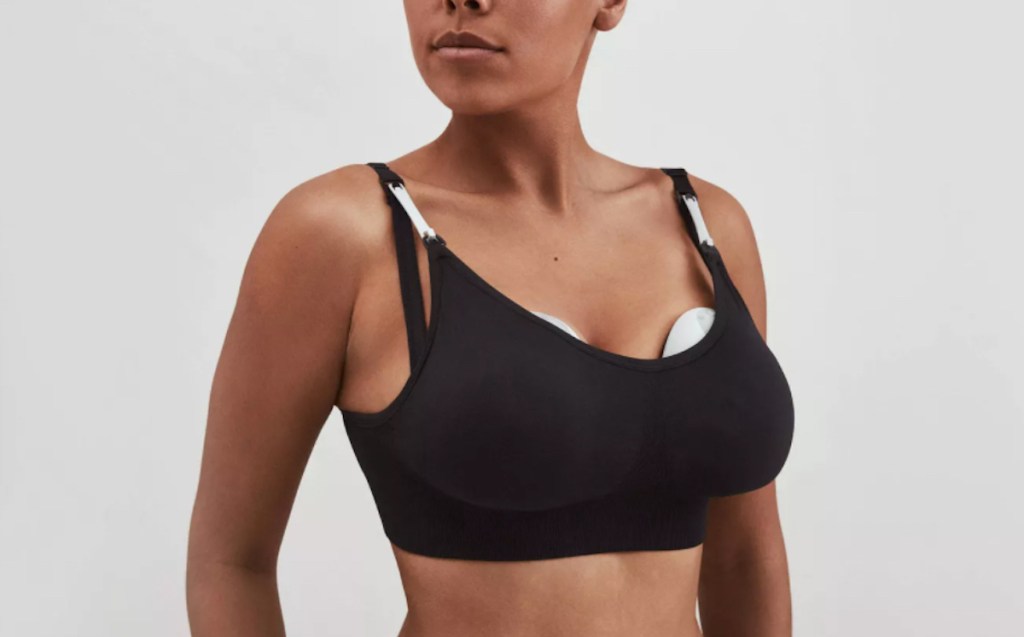 woman wearing nursing bra with hands free breast pump inside
