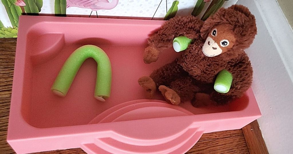 toy plush monkey using pool noodle in toy pool