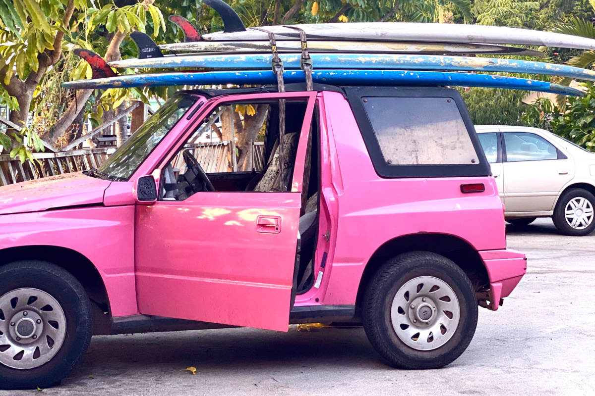 pink jeep with surfboards on top on hawaii vacation