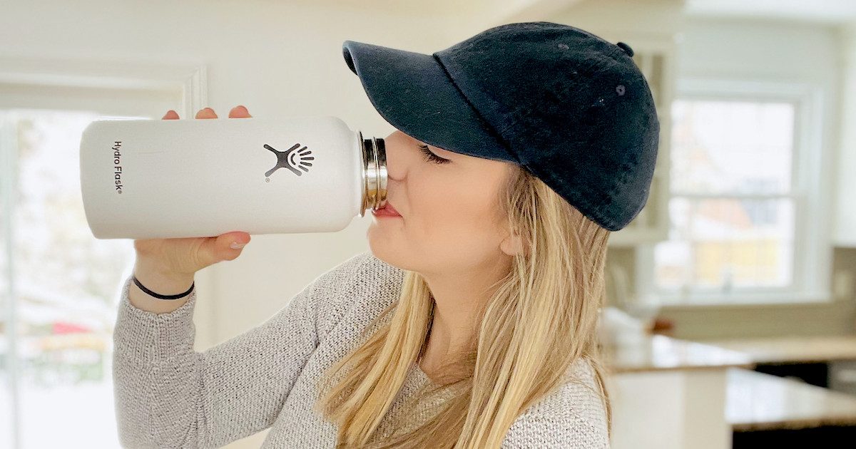 woman drinking out of white hydroflask water bottle