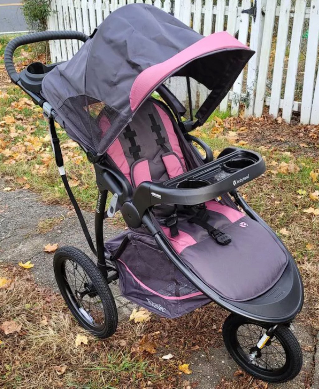 pink and gray jogging stroller outside on sidewalk
