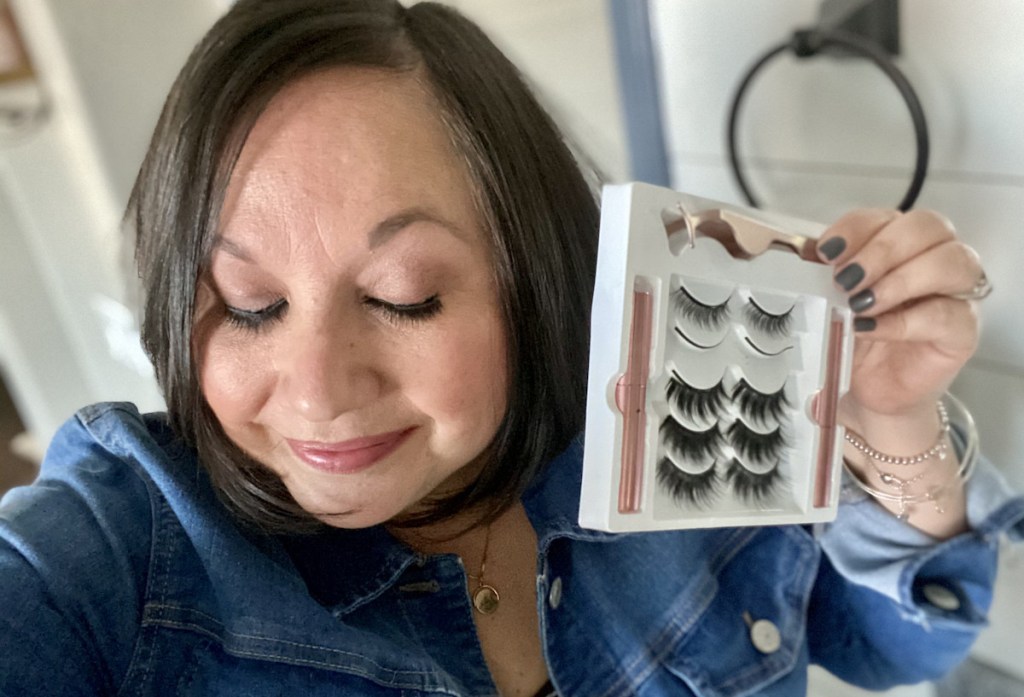 woman looking down holding box of magnetic lashes