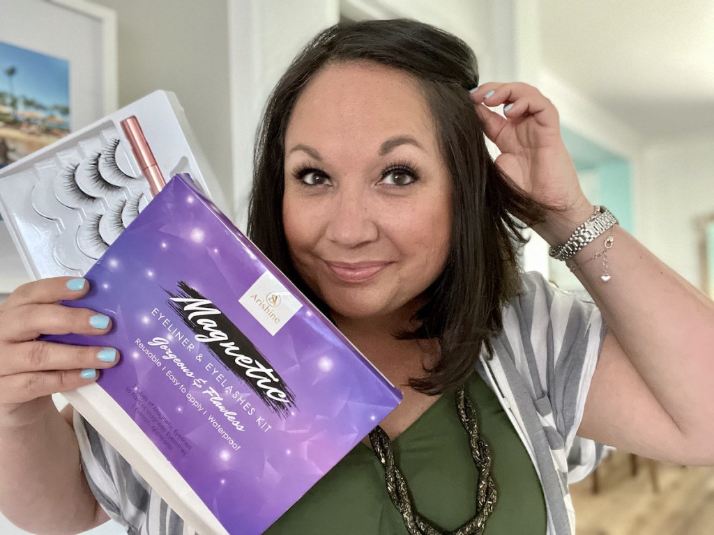 woman holding hair back while holding purple magnetic lashes box