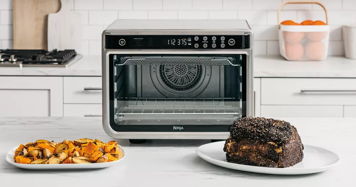 ninja air fryer pictured behind roasted meat and veggies