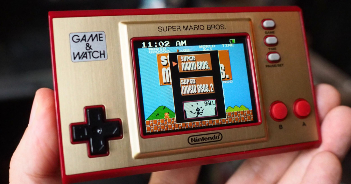 person holding nintendo game & watch
