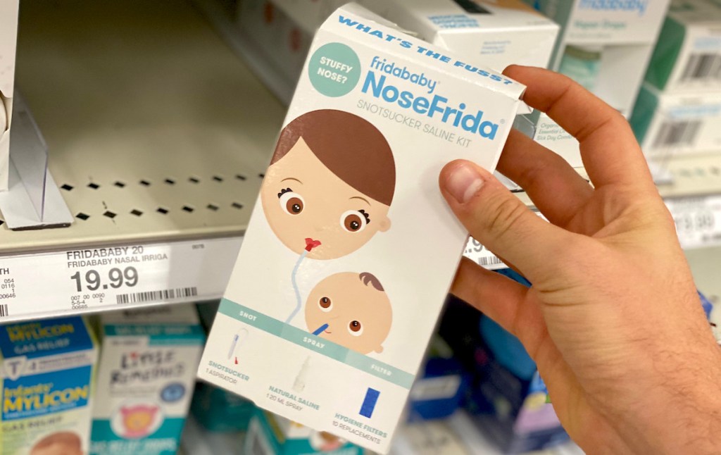 hand holding must have baby registry item nosefrida package in store aisle