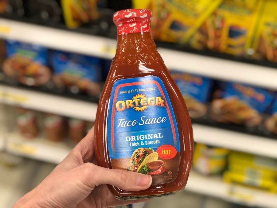 holding a jar of taco sauce