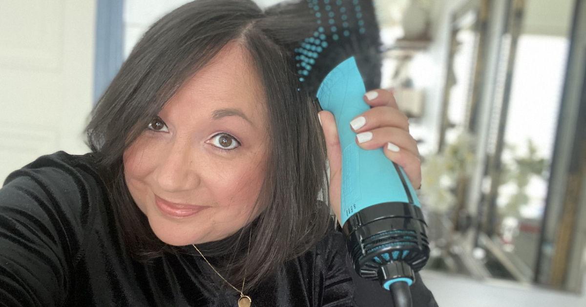 woman using a black and teal hair dryer