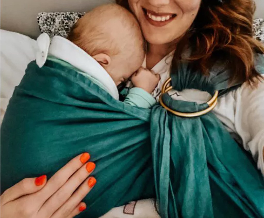 woman holding baby in emerald green ring sling 