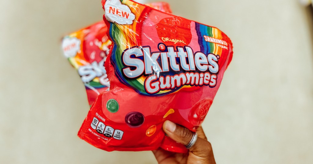 skittles gummies in hand in store