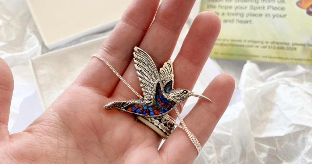 hand holding hummingbird pendant