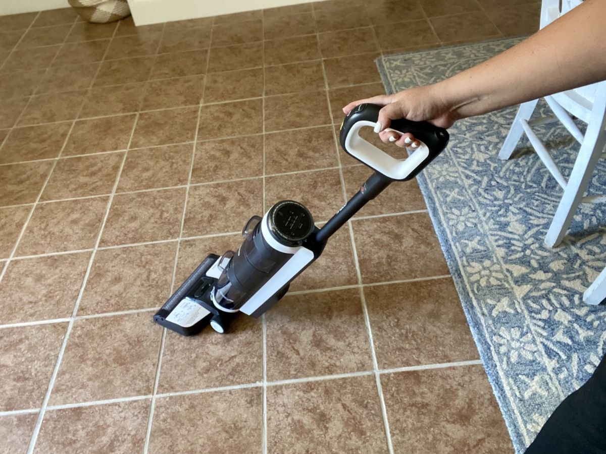 woman using vacuum on vinyl floor