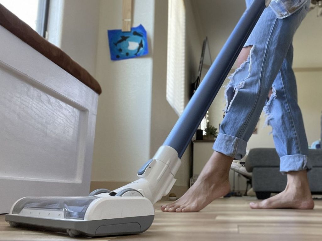 woman using vacuum on hardwood floors