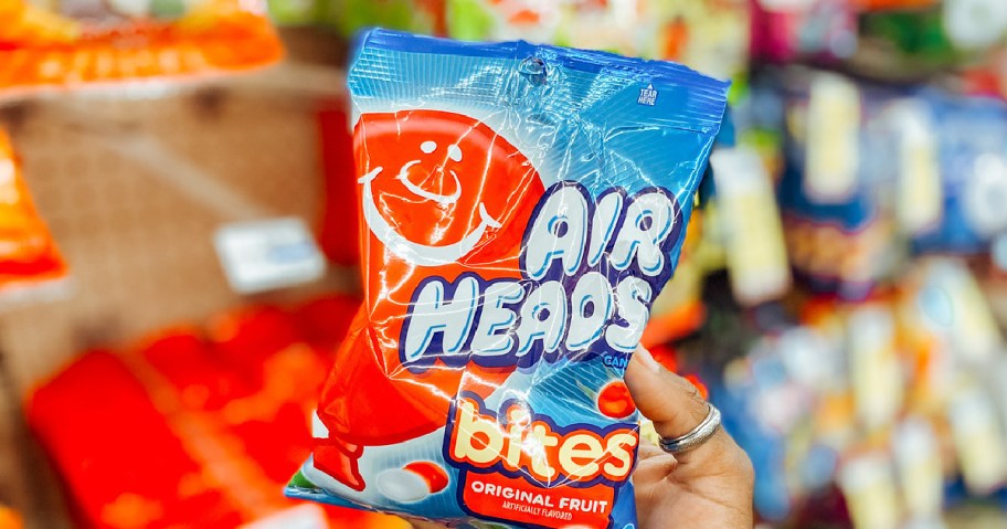 Hand holding up Air Heads candy bag