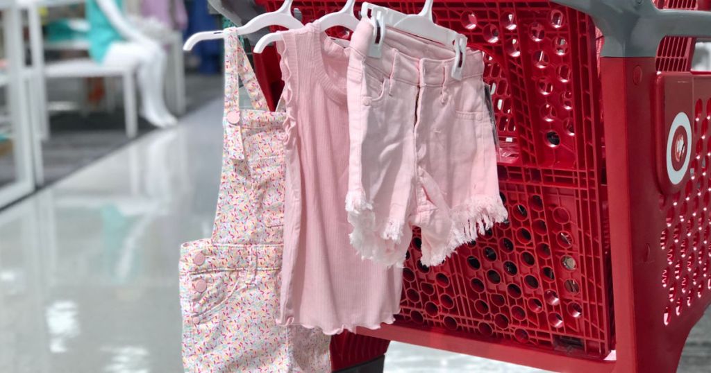 pink clothing hanging from red cart 