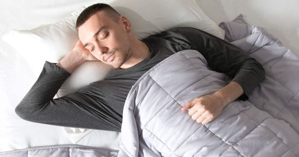 man sleeping under a weighted blanket