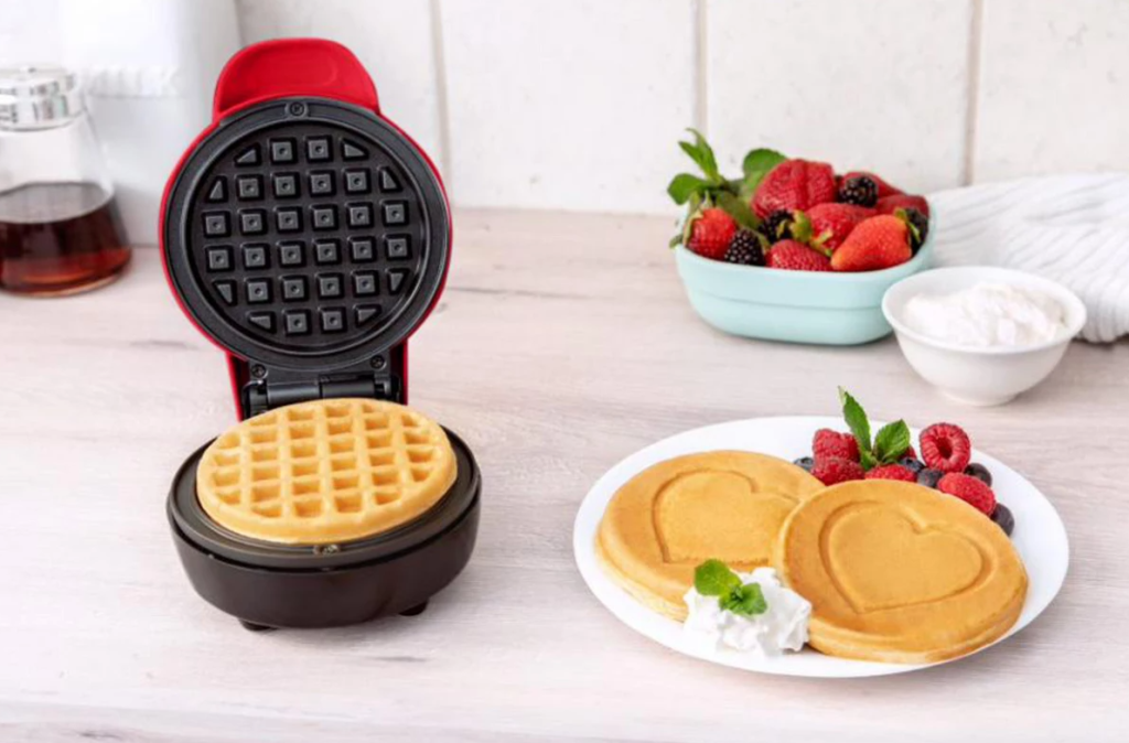 waffle maker next to a plate of waffles