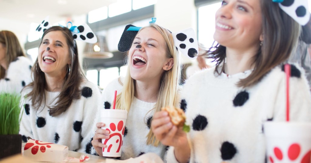 three women in cow costumes eating Chick-fil-A