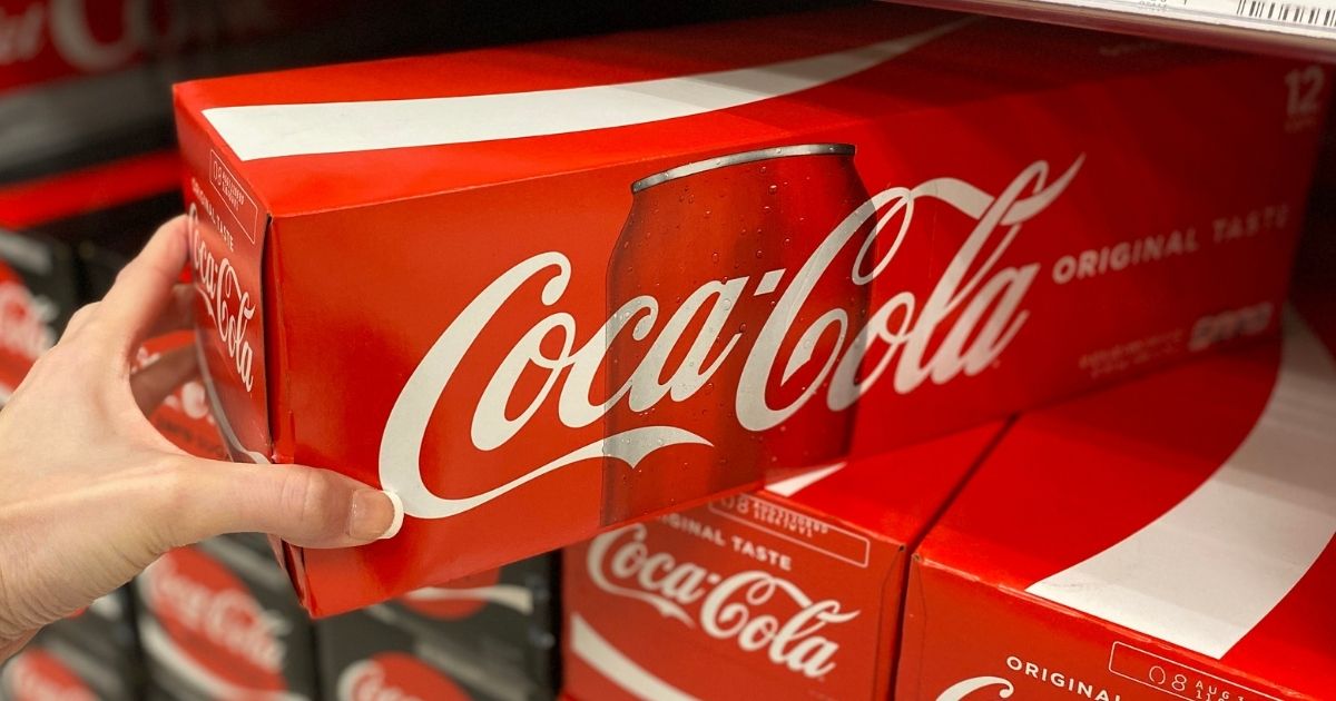 hand holding a 12-pack of coca-cola
