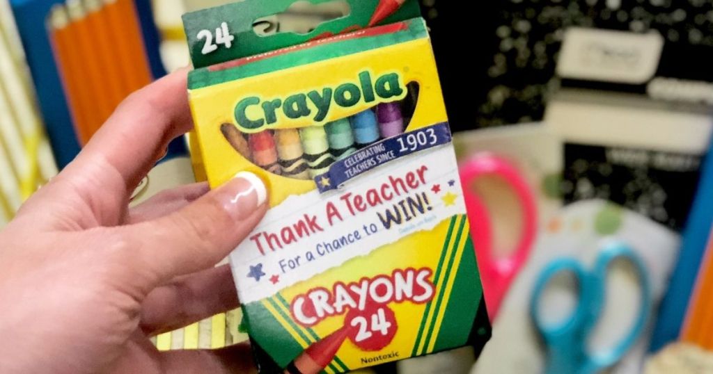 hand holding a pack of crayons