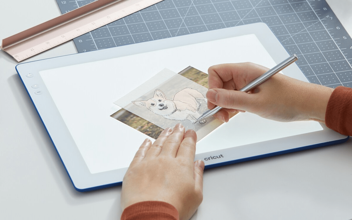 hands tracing a picture on a lightpad