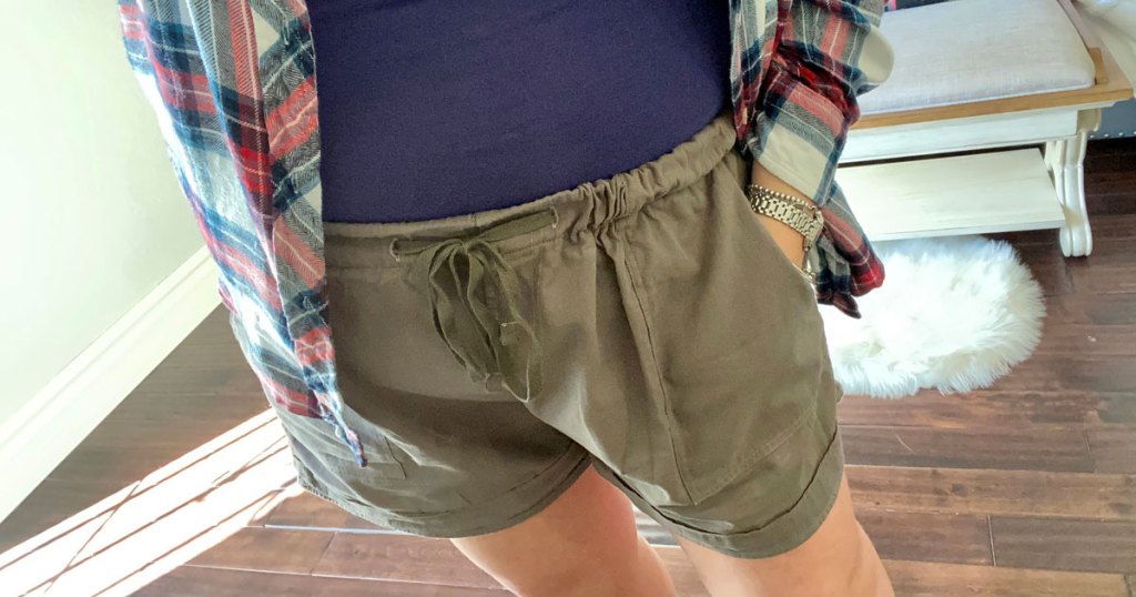 woman with hand in pocket of olive green shorts