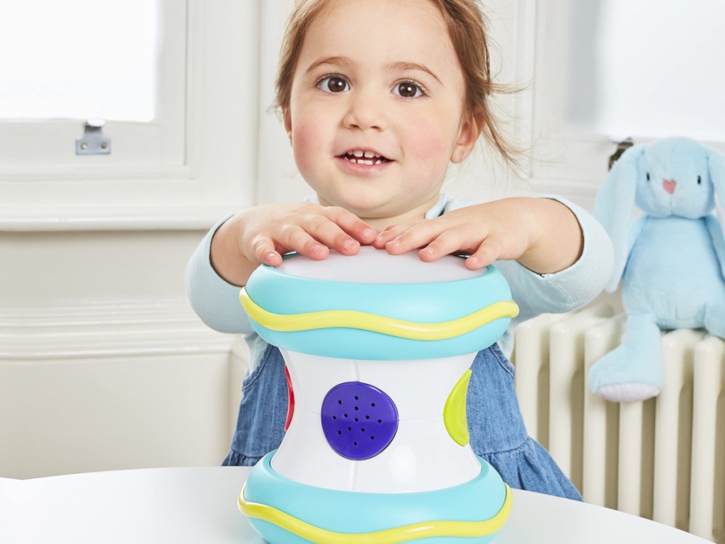 little girl playing with a lighted drum
