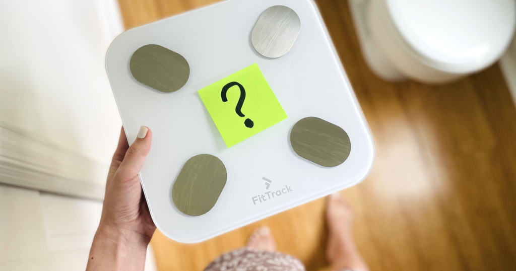 holding FitTrack smart scale 