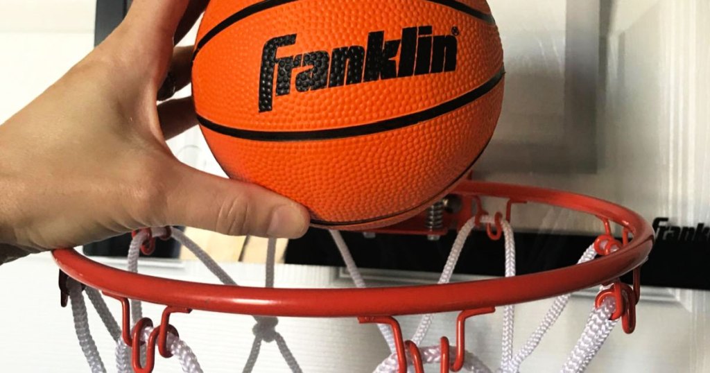 placing mini basketball into hoop