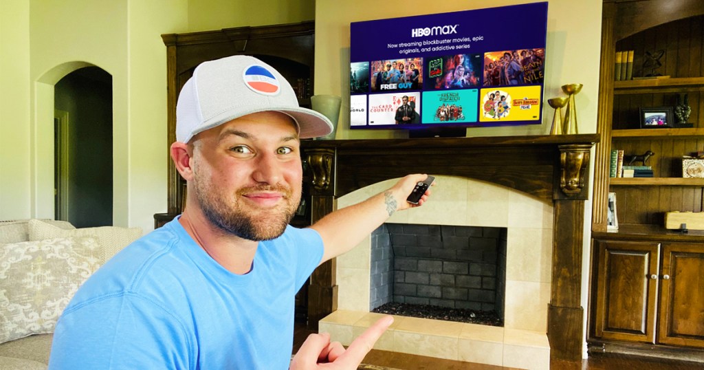 man pointing remote at tv