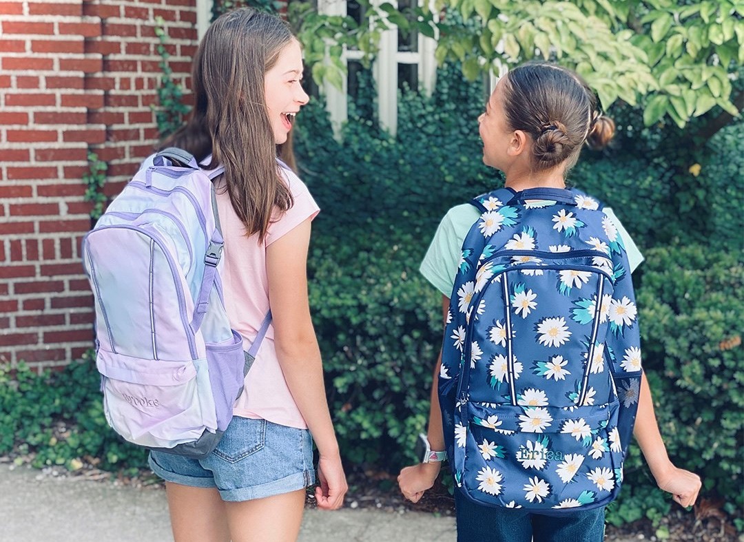 two girls wearing backpacks