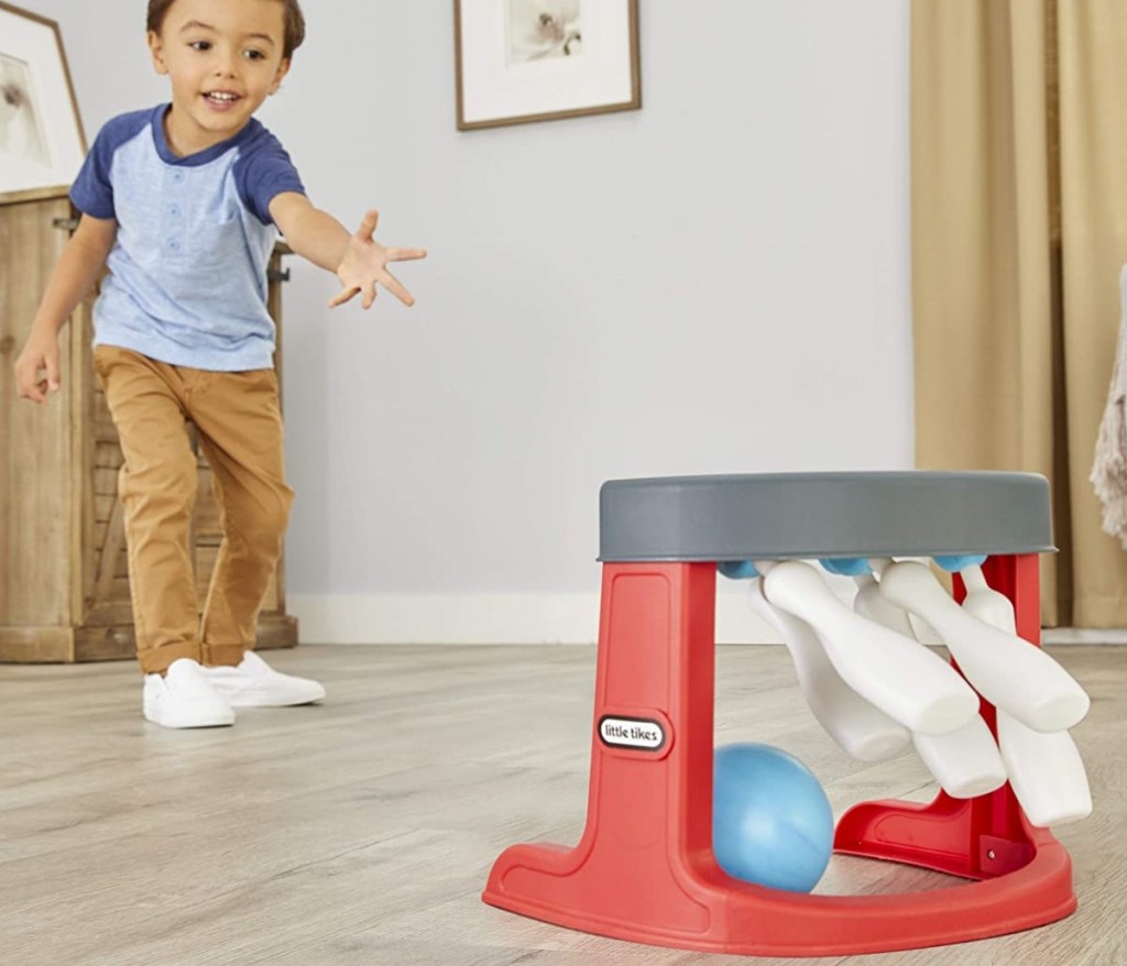 kid bowling with a toy set