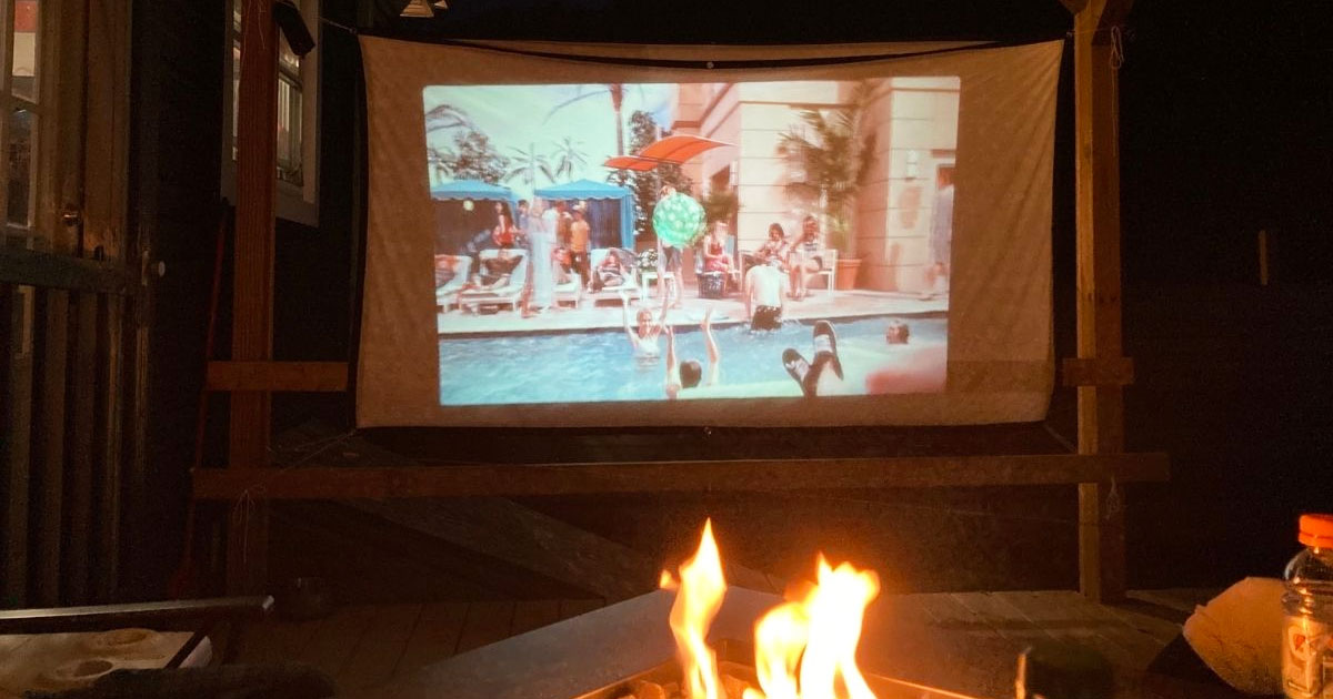 movie on screen outdoors in front of fire pit is one of the fun outdoor activities for kids near me