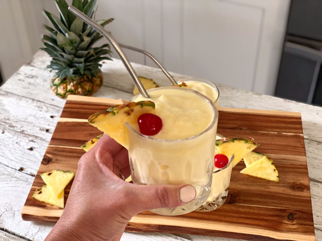 holding a glass of the best Pina Colada recipe