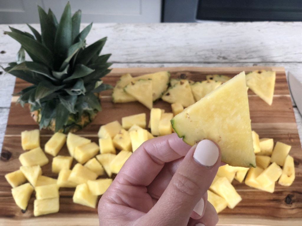 holding a pineapple wedge