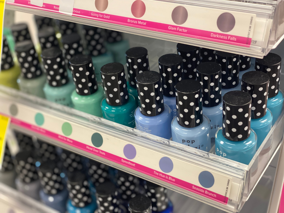 bottles of nail polish in various shades of blue and green on a store display