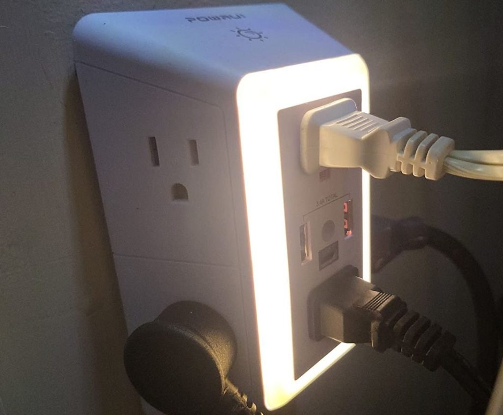 PowerUI Outlet Extender plugged into an an outlet with the night light on and a few plugs plugged into it