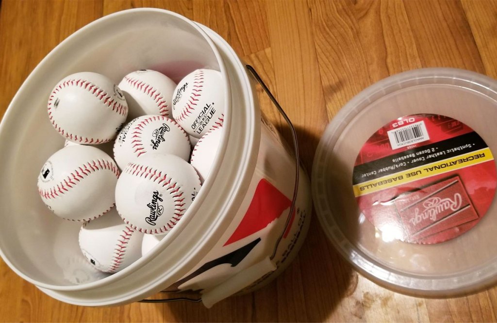 plastic bucket filled with baseballs