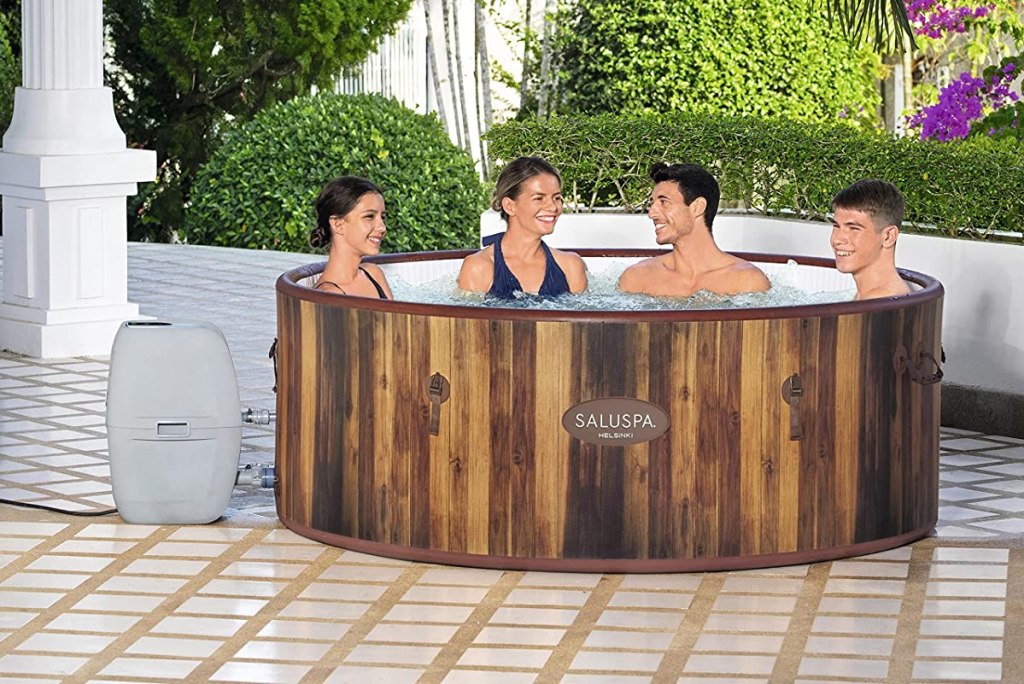 four people sitting in a hot tub