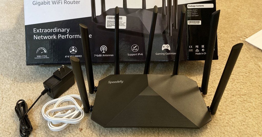 black wifi router with cables in front of box
