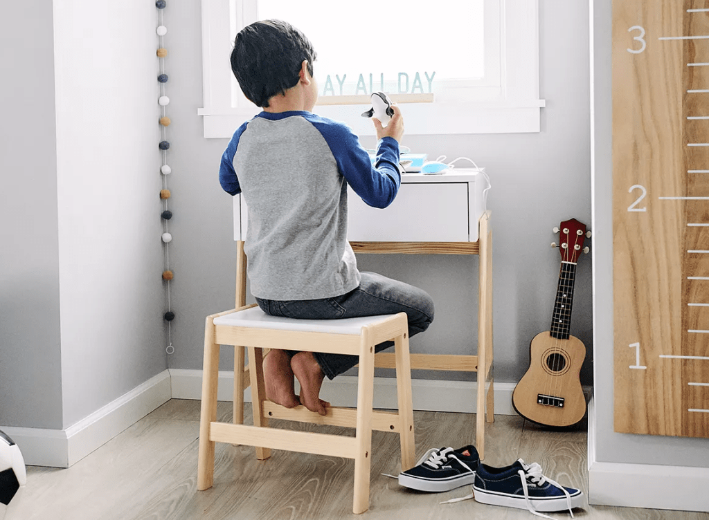 kid sitting at a table playing with toys