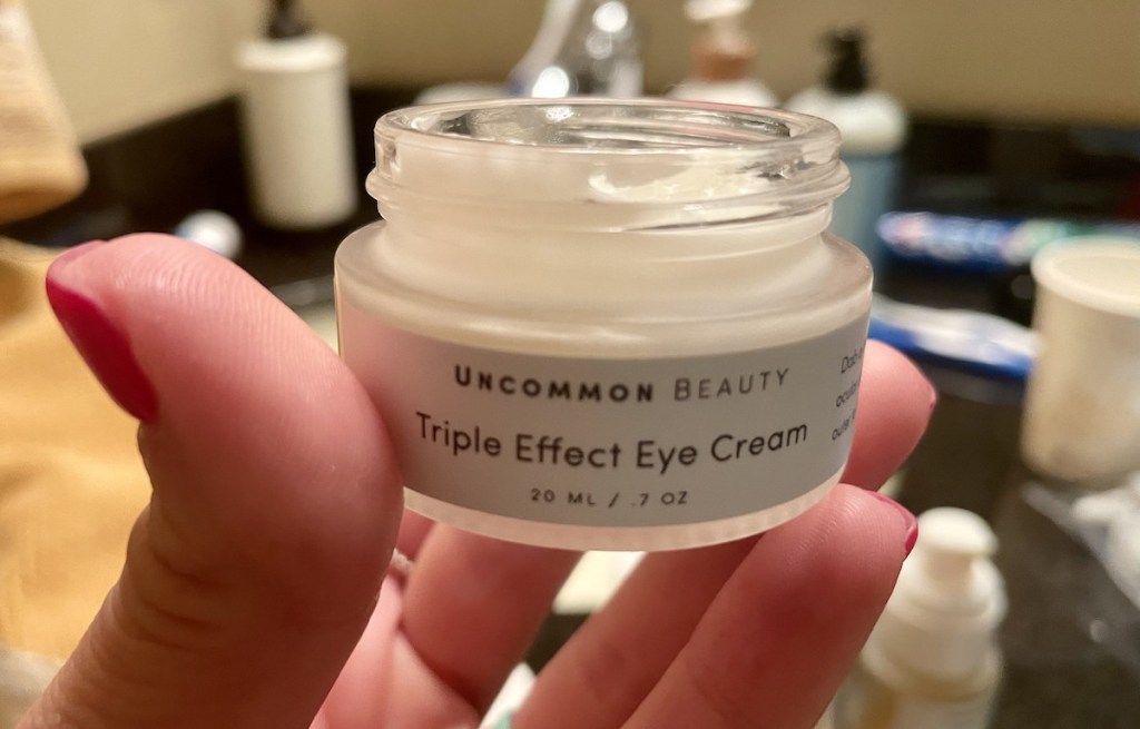 hand holding uncommon jeams beauty triple eye cream
